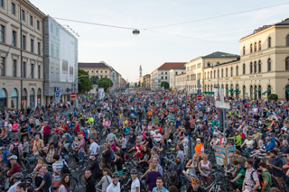 Ein Platz voller Menschen, von oben fotografiert, Gebäude laufen wir zwei Linien zentral zueinander im Horizont