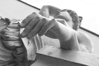eine Statur von unten fotografiert, sie steht schräg, die Hand ist größer als der Kopf aus dieser Perspektive