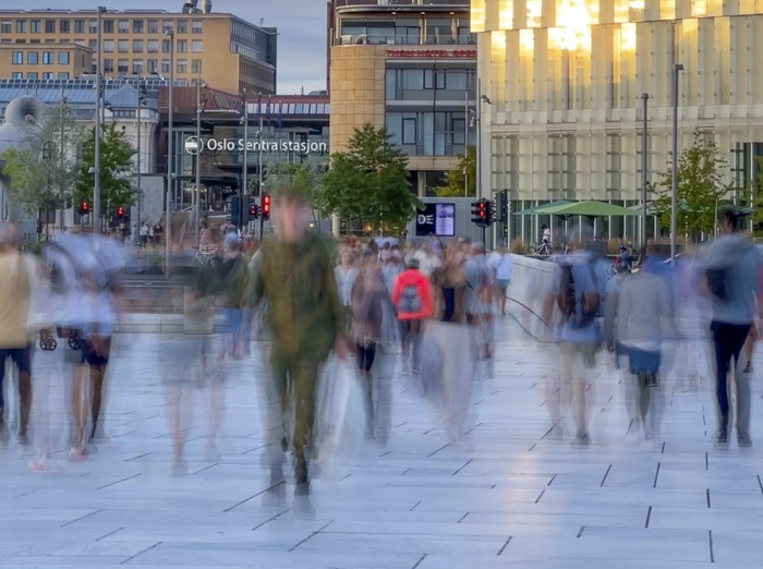 Workshop Smartphone Fotografie Grundlagen Langzeitbelichtung einer belebten Straße vor dem Osloer Hauptbahnhof, bei der die Bewegungen der Passanten verwischt dargestellt werden.