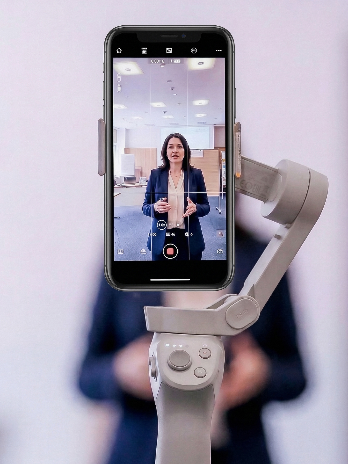 Smartphone auf einem Gimbal filmt eine Unternehmerin beim Videodreh.